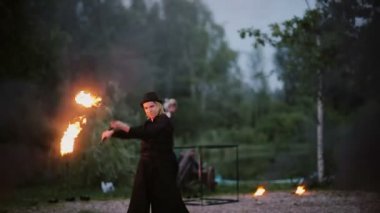 13.06.2015, Minsk, Beyaz Rusya. Ateşle dans adam. Yangın akşam doğada Show'da. Çizim yanan yollar.