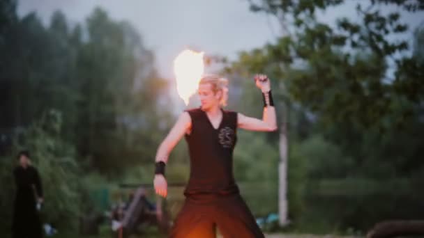 13.06.2015, MINSK, BELARUS. Spettacolo di fuoco la sera. Un uomo che porta fuori le prestazioni antincendio. Disegno sentieri fiammeggianti . — Video Stock