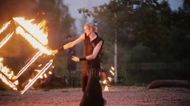 13.06.2015, MINSK, BELARUS. Performance solo avec cube en feu. Jeune homme faisant un tour dangereux, spectacle de feu . — Video