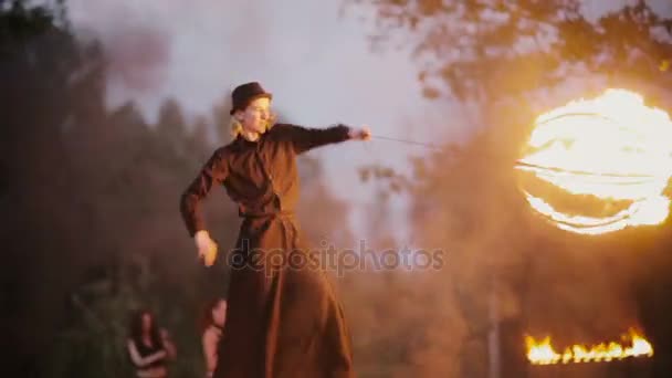 13.06.2015, Μινσκ, Λευκορωσία. Νεαρός άνδρας σε μια ξυλοπόδαρα δείχνει κόλπα με τη φωτιά. Τσίρκο ηθοποιού στο Φεστιβάλ του καλοκαιριού, Εμφάνιση fire. — Αρχείο Βίντεο