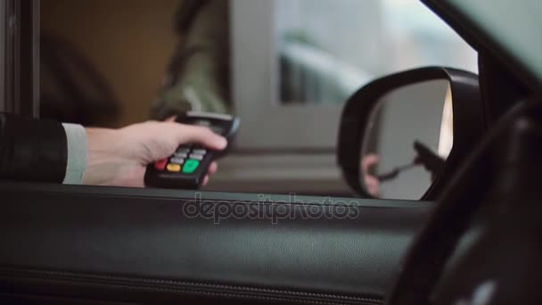 男は車内では、購入するための支払いクレジット カードは、Pin コードを入力します。車の窓から実業家の手のクローズ アップ ビュー. — ストック動画