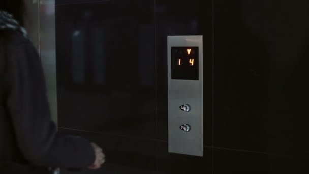 Donna con sciarpa premere il pulsante in ascensore. Donna in piedi in ufficio e utilizzando smartphone — Video Stock