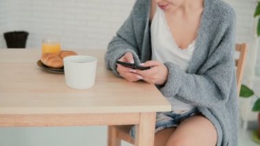 Yakın çekim manzara kahvaltı ve dokunmatik ekran kullanarak Internet tarama kadın. Kız okuma smartphone yeni.