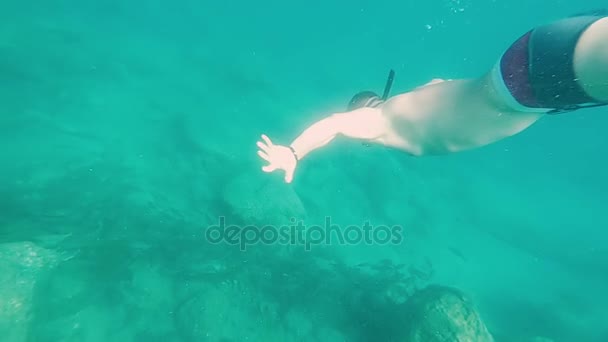 Hombre nadando bajo el agua usando una máscara de rostro completo. El macho flota en el fondo, buceando en un mar tropical. Movimiento lento — Vídeo de stock