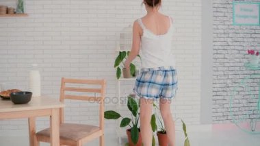Yalak mutfak sabah dans güzel ve genç birbayan. Çekici kız kahvaltı hazırlarken Pijama giyiyor.