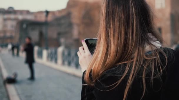 Reizende vrouw lopen in het centrum van de stad, Roman Forum. Vrouw neemt foto van oude stad en muzikant op smartphone. — Stockvideo