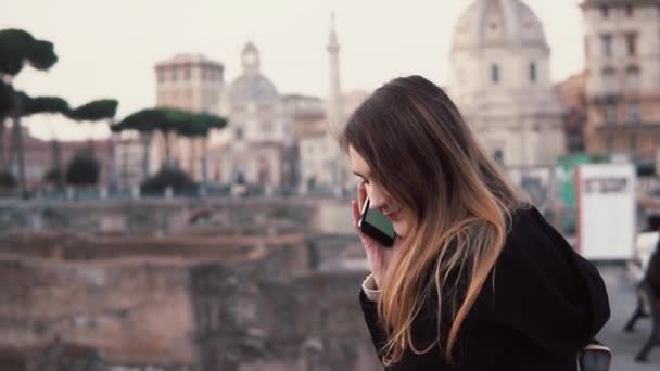 Jonge vrouw lopen in het centrum van de stad, Roman Forum. Vrouwelijke reiziger praten aan de telefoon. Meisje verkennen van Italië. — Stockvideo