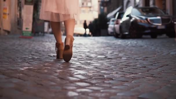 Mujer caminando por el camino empedrado del pavimento. Chica explorando nueva ciudad vistiendo zapatos y falda. Vista de primer plano . — Vídeos de Stock