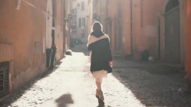 Güneşli bir günde küçük Caddede yürüyen genç turist kadın. Eski şehir keşfetmek Avrupa'da tatil harcama kız.