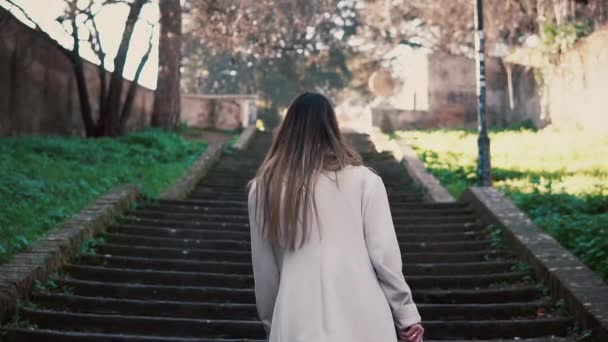 Stijlvolle jongedame wandelen in de oude straat van de stad, het traplopen. Meisje uitgaven vakantie in Europa. — Stockvideo