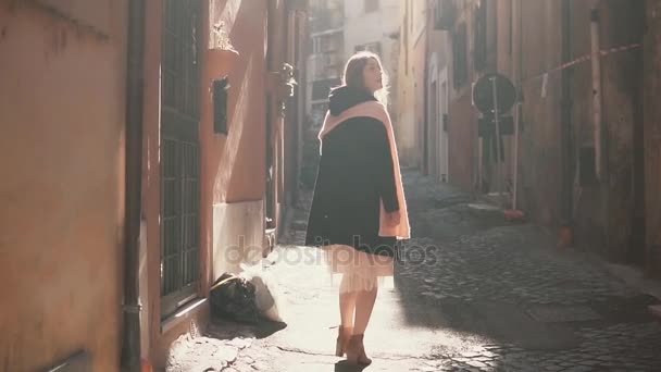 Portrait of young stylish woman walking in the alley, side street. Happy girl explores the old part of the city. — Stock Video