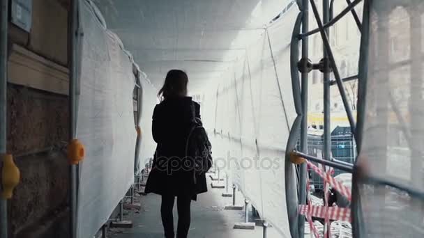 Studentinnen gehen durch den weißen Baukorridor. Rückansicht einer jungen Frau geht quer durch das Gebäude zur Arbeit. — Stockvideo