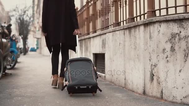 Ταξιδιώτης γυναίκα πόδια περπάτημα κουβαλώντας μία βαλίτσα σε ένα δρόμο της πόλης. Κορίτσι που έρχονται για διακοπές στην Ευρώπη. — Αρχείο Βίντεο