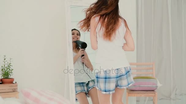 Молода жінка співає, використовуючи фен як мікрофон. Дівчина танцює в піжамі перед дзеркалом. Повільний рух . — стокове відео