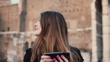 Roma Forumu keşfetmek Smartphone kullanan genç kadın. Roma, İtalya'da tatil harcama kız şehirde yürüyüş.