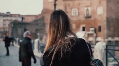 Şehir merkezinde yürüyen esmer kadın Roman Forum. Eski şehir ve müzisyen fotoğrafı kadın turist alır.