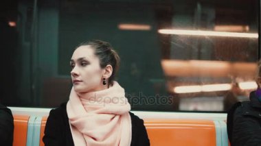 Metroda oturan genç güzel kadın. Toplu taşıma araçları ile çalışmaya çekici düşünceli kız gider.