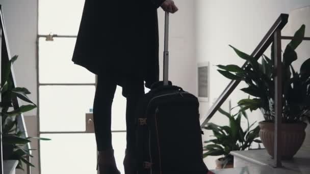 Vista de perto da jovem empresária com mala. Viajante menina vem para baixo na escada com bagagem . — Vídeo de Stock