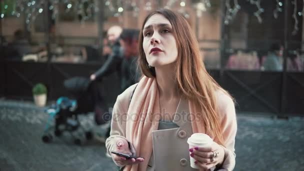 Aantrekkelijke vrouw staande voor Toon-venster en het drinken van thee. Brunette meisje dromen te kopen iets, zuchten. — Stockvideo