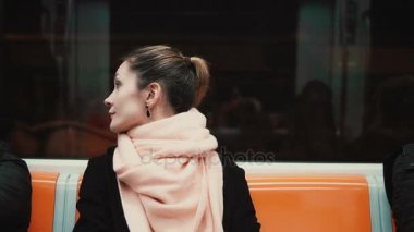 Metroda oturan genç ve düşünceli kadın portresi. Kız toplu taşıma, çevresinde, penceresine bakarak kullanır.