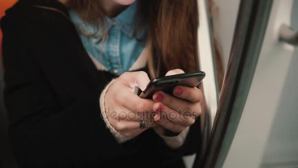 Vista de cerca de la mano de una mujer sosteniendo un teléfono inteligente, sentado en el transporte público. Chica navegar por Internet con pantalla táctil . — Vídeos de Stock