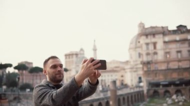 Turist adam alır selfie Fotoğraflar şehir merkezi Roma, İtalya'nın arka planı onun smartphone ile gülümseyen.