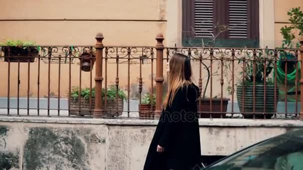 Mujer viajera joven explorando la nueva ciudad. Chica atractiva caminando por el casco antiguo y mirando a su alrededor. Movimiento lento . — Vídeo de stock