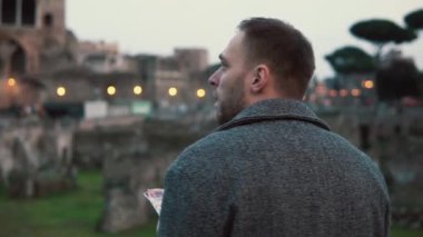 Kalıntıları Roma, İtalya, ayakta, etrafa adam. Erkek ilginç yerler bulmak için haritaya benziyor. Ağır çekim.