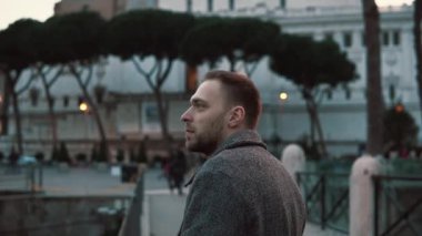 Yakışıklı bir adam Roma İtalya'nın manzaraları akşam, bak etrafında dikkate alır ve gezi sahiptir. Ağır çekim.
