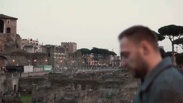 Hombre guapo morena con barba de pie en las ruinas de Roma, Italia, mirando el mapa en sus manos. Movimiento lento . — Vídeos de Stock