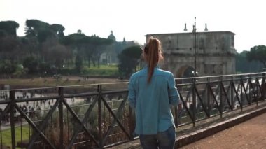 Kadın Roma, İtalya sokakta yürüyor, Colosseum, Constantine arch ile smartphone fotoğraflarını çeker. Ağır çekim.