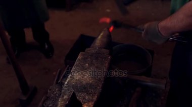 Örs atölye bir çekiç ile bir at nalı dövme bir demirci. Sıcak kırmızı metal ile çalışan adam.