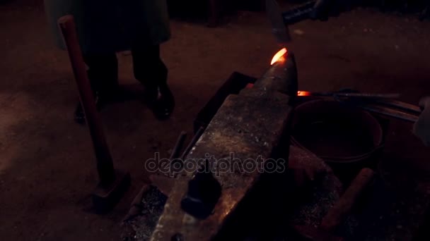 Close-up beeld van smid werken met hamer en hete rode metaal. Man die hoefijzer op het aambeeld in smithy. — Stockvideo