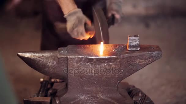 Коваль працює з молотком і гарячим червоним металом. Двоє чоловіків підробляють залізо на ковадлі в ковалі . — стокове відео
