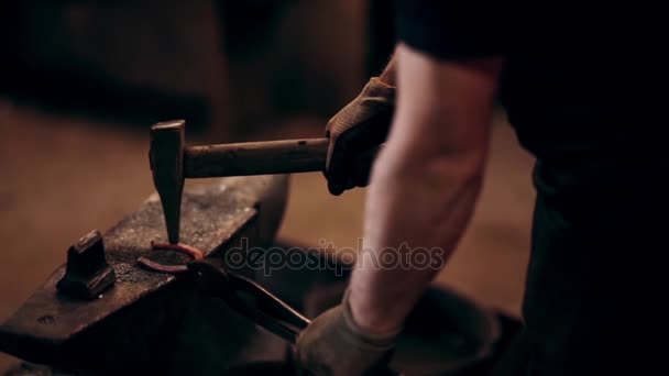 两个男人一起制作马蹄铁的锤子。在工作场所，围裙的铁匠使用热金属. — 图库视频影像