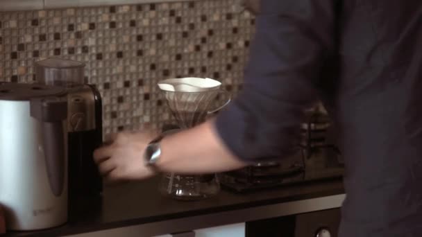 Vista de cerca de un joven usando cafetera chemex. Barista pone café en el filtro en la cocina . — Vídeos de Stock
