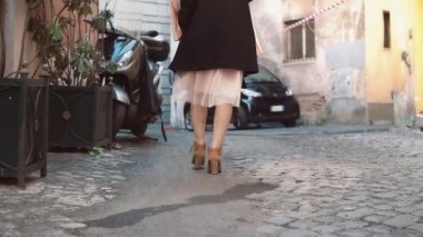 Yakın çekim genç şık kadın kaldırım taşı kaldırım yolda yürürken bir bakış. Kız sokağın gidiyor. Ağır çekim.