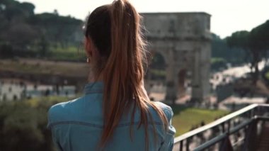 Genç esmer kadın turist Konstantin fotoğraflarını çeker s arch ve Roma, İtalya, smartphone, gülümseyen. Ağır çekim.