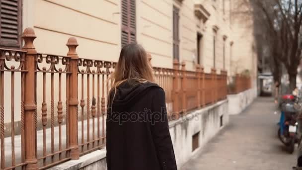 Mujer joven caminando en el centro de la ciudad. Chica con equipaje mudándose a un nuevo lugar y ahora explorando la ciudad. Movimiento lento . — Vídeo de stock