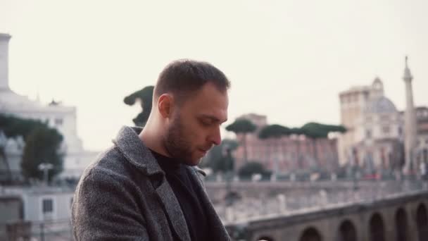 Man tourist se trouve au centre de Rome, en Italie. Le beau mâle utilise smartphone, sert l'Internet . — Video