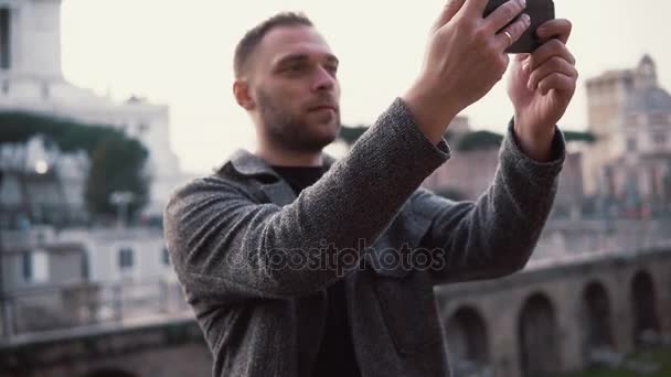 Homem turista explora nova cidade, tira fotos selfie do centro da cidade no smartphone. Masculino gosta de viajar para Roma, Itália . — Vídeo de Stock