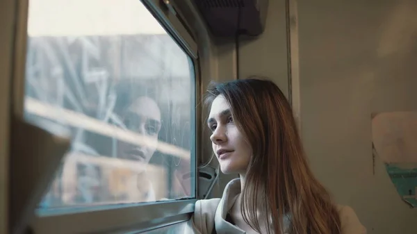 Mooie jongedame reizen met de trein. Aantrekkelijk meisje venster kijken en het verkennen van het landschap buiten. — Stockfoto