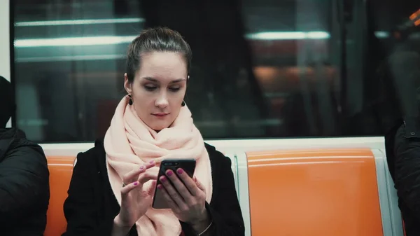 Menina atraente no trem do metrô usando smartphone. Mulher jovem navegar na Internet com tecnologia touchscreen . — Fotografia de Stock