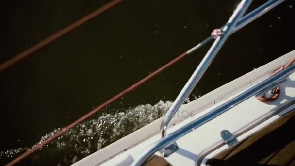 Kant van de zeilboot gaat door de golven met volle snelheid. Zeilen in de wind in zonnige dag. Close-up weergave. — Stockvideo