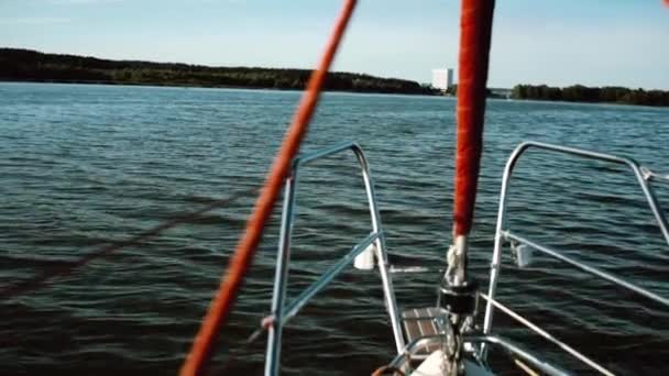 Parte nasal del velero pasa por las olas en el lago. Navegar en el viento en un día soleado. Vista de primer plano . — Vídeos de Stock