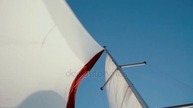 Beyaz ve kırmızı yelken parlak yaz günde rüzgarda sallayarak yakından görmek. Hız sailboard.