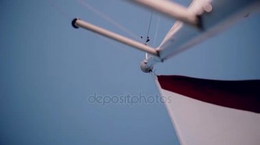Beyaz ve kırmızı yelken parlak yaz günde rüzgarda sallayarak. Yakın çekim hızı sailboard görünümünü. Güneş parlıyor.
