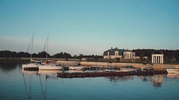 Holzsteg im Sommer. Segelbretter, die in Ufernähe stehen. Morgen in der Natur. — Stockvideo