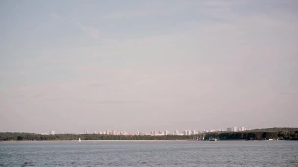 Uitzicht vanaf de bewegende schip naar de stad landschap. Zonnige heldere dag in het open water, meer met blauw water landschap. — Stockvideo