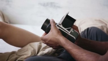 Fotoğrafçı alarak fotoğraf yakından görmek eski hareketli-film kamera. Genç kadın adama poz pijama.